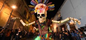 Día de muertos en Oaxaca: comparsa con una calavera monumental en las calles
