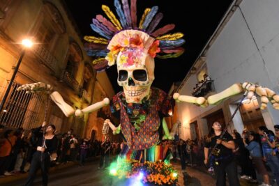 Día de muertos en Oaxaca: comparsa con una calavera monumental en las calles