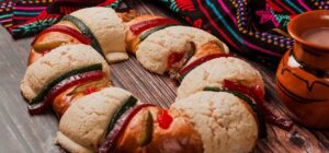 Rosca de reyes: rosca decorada con frutas cristalizadas junto a una taza de chocolate