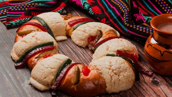 Rosca de reyes: rosca decorada con frutas cristalizadas junto a una taza de chocolate